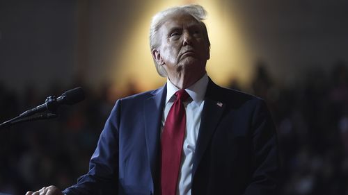 President Donald Trump watches a video screen at a campaign rally.